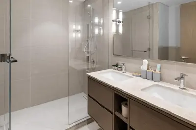 a bathroom with a sink and a glass shower at Luxury Stay Just Steps from Dubai Mall 2BR Grande in Dubai