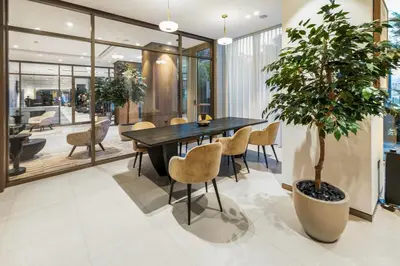 a dining room with a table and a potted tree at Luxury Stay Just Steps from Dubai Mall 2BR Grande in Dubai