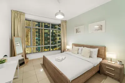 a bedroom with a bed and a desk and a window at FIRST CLASS 2BR Elegant Urban Retreat in Dubai