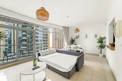 a living room with a couch and a large window at FIRST CLASS 2BR Elegant Urban Retreat in Dubai
