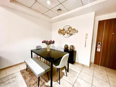 a dining room with a black table and chairs at Chic 1BR with the City Views in Dubai