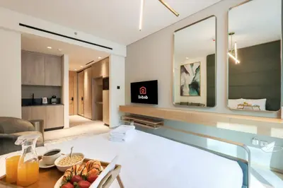a living room with a table with a bowl of fruit at Livbnb - Stylish Studio in JVC, Near Parks and Shops in Dubai