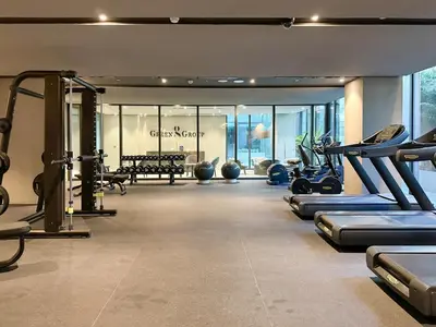 a gym with treadmills and machines in a room at Livbnb - Stylish Studio in JVC, Near Parks and Shops in Dubai