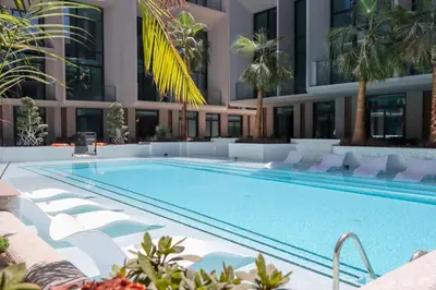 a swimming pool in front of a building at Livbnb - Stylish Studio in JVC, Near Parks and Shops in Dubai