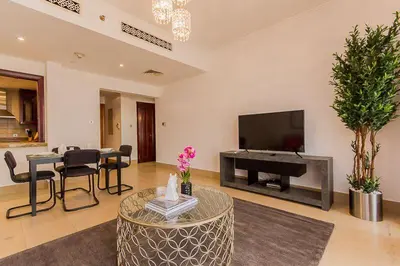 a living room with a television and a table with chairs at Cozy 1BR Apart Downtown Burj Khalifa and Dubai Mall in Dubai