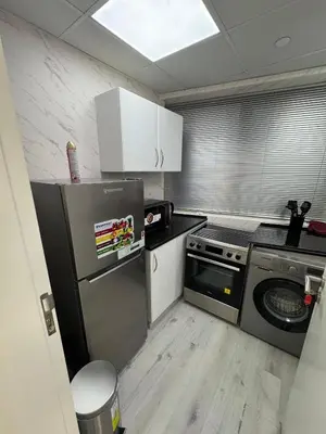 a small kitchen with a refrigerator and a dishwasher at Icon tower 1 , JLT 1BHK apartment in Dubai