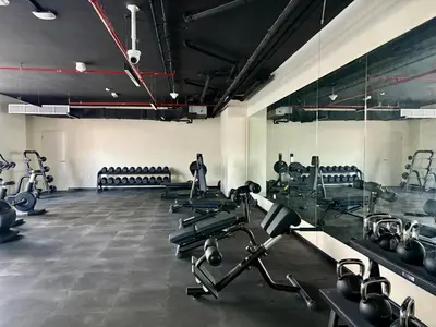 a gym with several rows of treadms and machines at FIRST CLASS 2BR Sleek Urban Oasis in Dubai