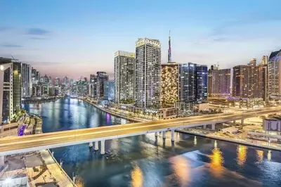 a city skyline with a river and a bridge at FIRST CLASS 2BR Sleek Urban Oasis in Dubai
