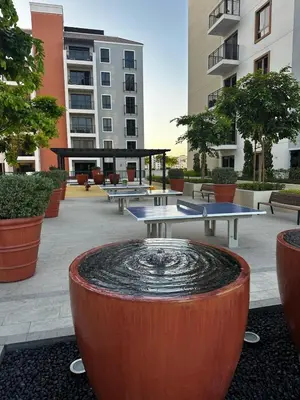 a group of tables and a fountain in a courtyard at 2BR by Sea, 15min to Dubai Mall in Dubai