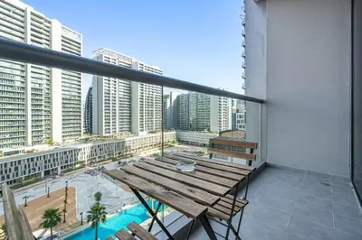 a balcony with a wooden table and a view of a city at Vibrant&Chic - Studio - 6MN Dubai Mall - Pool&Gym in Dubai