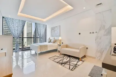 a bedroom with a bed and a couch and a chair at Vibrant&Chic - Studio - 6MN Dubai Mall - Pool&Gym in Dubai