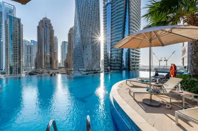 a swimming pool with chairs and an umbrella in a city at 1BR Jumeirah Living - Marina View - 5 STARS Facilities in Dubai