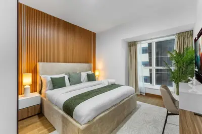 a bedroom with a large bed and a window at Stylish 2BR in Elite Tower with Bluewaters View and JBR in Dubai