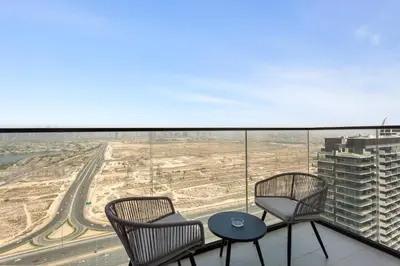 two chairs and a table on the balcony of a building at Stylish 1-Bedroom in Binghatti House JVC in Dubai