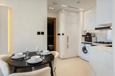 a kitchen and dining room with a table and chairs at Stylish 1-Bedroom in Binghatti House JVC in Dubai