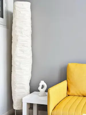 a yellow chair and a side table with a lamp at Canal Luxe Burj 1BR Sleeps 4 with Pool and Gym in Dubai
