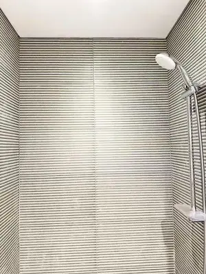 a bathroom with a shower and a lamp at Canal Luxe Burj 1BR Sleeps 4 with Pool and Gym in Dubai