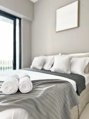 a bedroom with a bed with towels on it at Canal Luxe Burj 1BR Sleeps 4 with Pool and Gym in Dubai