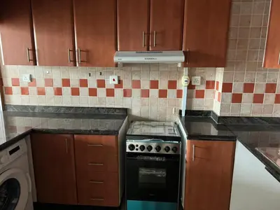 a kitchen with wooden cabinets and a stove top oven at Dream home in Dubai