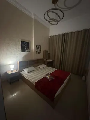 a bedroom with a large bed with a red blanket at Dream home in Dubai