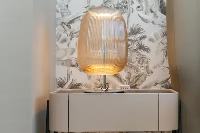 a lamp on top of a white dresser at WOW Port de la Mer Skyline Blick Dubai in Dubai