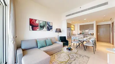 a living room with a couch and a dining room at Grand Bleu 2 - Sophisticated Two Bed with Sea View in Dubai