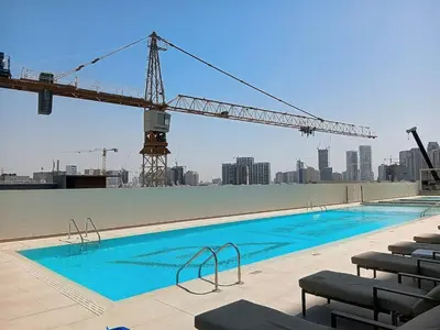 a crane on the side of a building with a pool at Binghatti House - Two Bedroom with Private Pool in Dubai