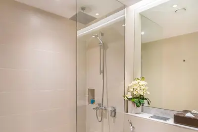 a bathroom with a shower with a glass door at La Mer 1BR Ocean View 4 Pax in Dubai