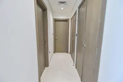 an empty corridor with a door in a building at Chic 2BR Heart of District One in Dubai