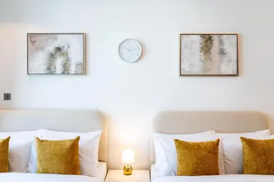a bedroom with two beds and a clock on the wall at Luxurious New Studio! 2 Double Beds! Sleek Design & High-End Amenities in Dubai Downtown in Dubai
