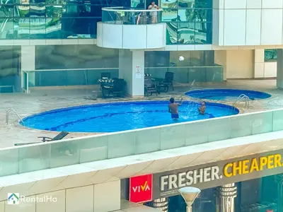 two people in a swimming pool in a building at Amazing New Design Flat with Rooftop Pool in Dubai Marina 5 pax in Dubai