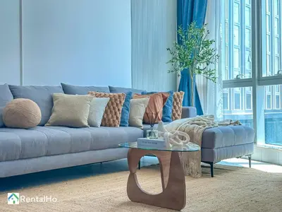a living room with a blue couch and a table at Amazing New Design Flat with Rooftop Pool in Dubai Marina 5 pax in Dubai