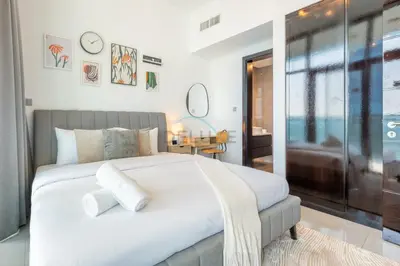 a bedroom with a large white bed and a table at 2BR Near Burj Khalifa & Business Bay Metro Station, Merano Tower, Business Bay in Dubai