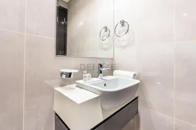 a white bathroom with a sink and a mirror at 2BR Near Burj Khalifa & Business Bay Metro Station, Merano Tower, Business Bay in Dubai