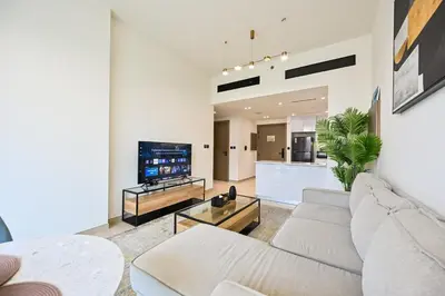 a living room with a couch and a tv at Stunning 1 br modern luxury residence at JVC in Dubai