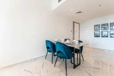 a dining room with a table and blue chairs at HAVN - Upgraded 1 Bed in 8 Boulevard Walk Downtown in Dubai