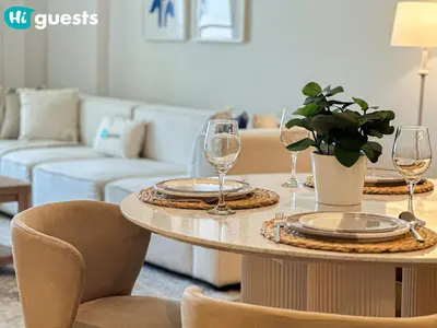 a table with plates and glasses on it in a living room at HiGuests - Seaside Serenity 1 BR at Port De La Mer in Dubai