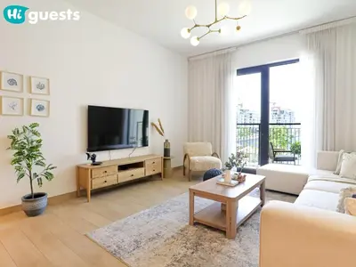 a living room with a couch and a tv at HiGuests - Seaside Serenity 1 BR at Port De La Mer in Dubai