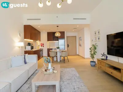 a living room with a white couch and a table at HiGuests - Seaside Serenity 1 BR at Port De La Mer in Dubai