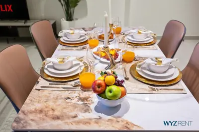 a table with plates and fruit on top of it at Urban Glam 1 BR in Surf 2-Creek Beach Access in Dubai