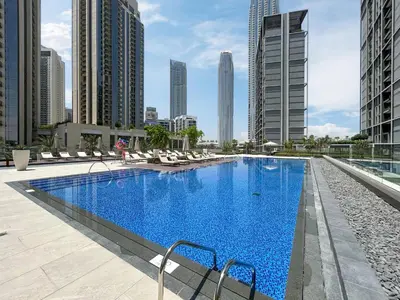 a large swimming pool with chairs and buildings at Brand New Creek Home with Panoramic Water View in Dubai