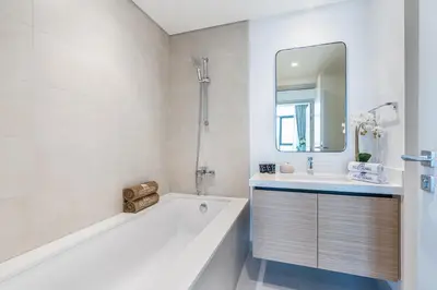 a bathroom with a tub and a sink and a mirror at Brand New Creek Home with Panoramic Water View in Dubai