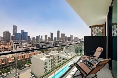 a balcony with two chairs and a view of a city at Stylish 1BR Apartment in Binghatti Onyx JVC in Dubai