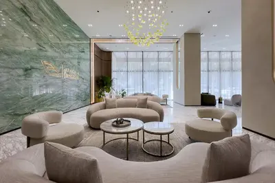 a lobby with couches and chairs and a chandelier at Stylish 1BR Apartment in Binghatti Onyx JVC in Dubai