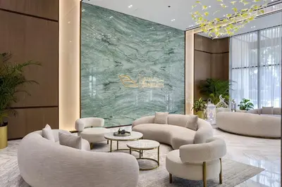 a lobby with couches and tables and a green wall at Stylish 1BR Apartment in Binghatti Onyx JVC in Dubai