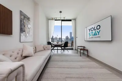 a living room with a couch and a table at Stylish 1BR Apartment in Binghatti Onyx JVC in Dubai