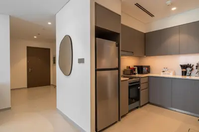 a kitchen with a stainless steel refrigerator and cabinets at Full Burj Khalifa and Fountain View from All Rooms in Dubai
