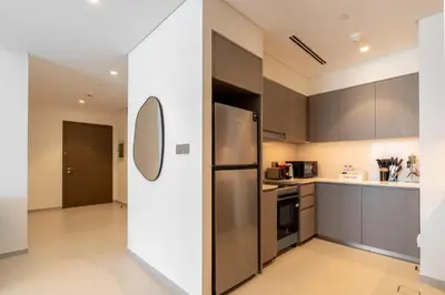 a kitchen with a stainless steel refrigerator and cabinets at Full Burj Khalifa and Fountain View from All Rooms in Dubai