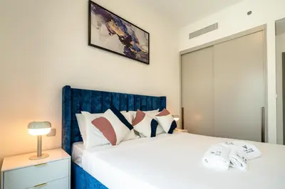 a bedroom with a white bed with a blue headboard at Burj & Fountain View Retreat in Dubai
