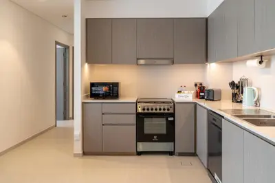 a kitchen with a stove and a microwave at Burj & Fountain View Retreat in Dubai